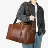 1 (1) Man holding brown leather duffle bag, casual outfit