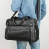 1 (11) Man holding black leather duffle bag, casual denim outfit