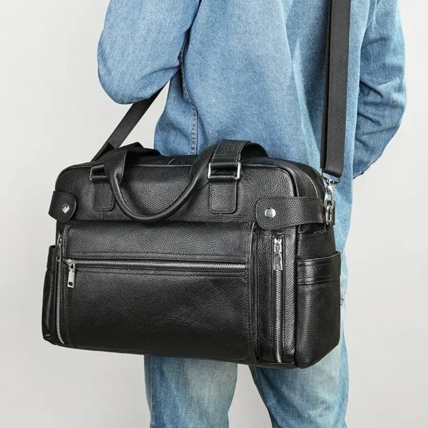 1 (11) Man holding black leather duffle bag, casual denim outfit