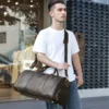 1 (13) Young man holding brown leather duffle bag, casual street style
