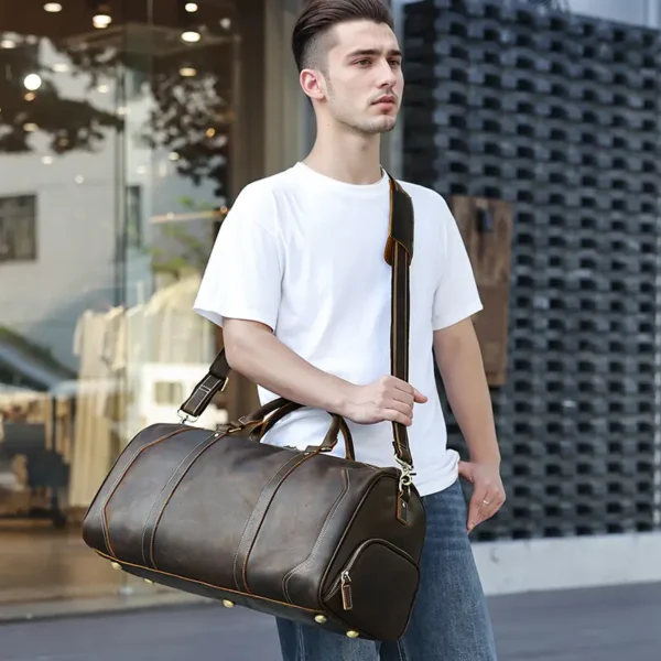 1 (13) Young man holding brown leather duffle bag, casual street style