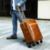 1 (2) Warm brown leather trolley suitcase with smooth finish, studio shot