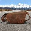 1 (26) Brown leather sling bag on mountain background, rustic style