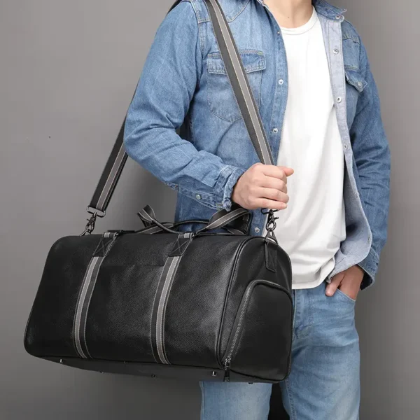 1 (6) Man holding black leather duffle bag, casual denim style