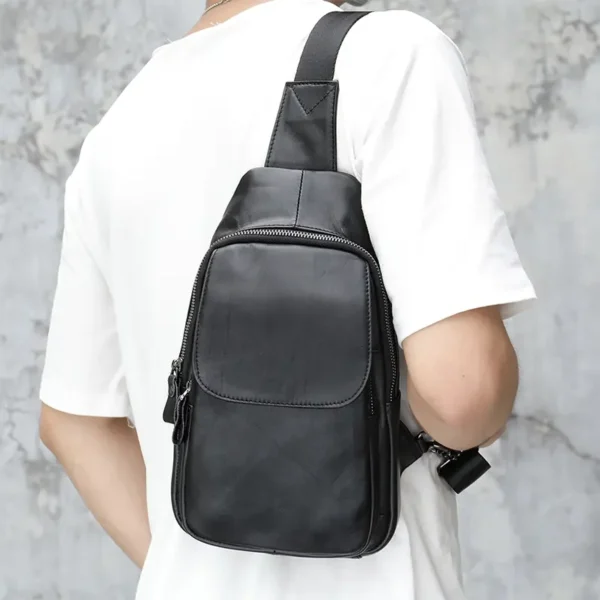 12 Man carrying black leather sling bag, back view