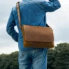 2 Brown leather messenger bag on rustic wooden background