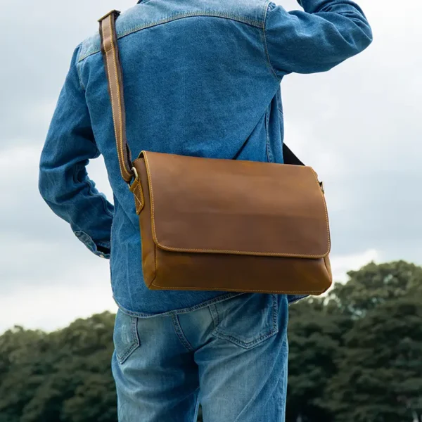 2 Brown leather messenger bag on rustic wooden background