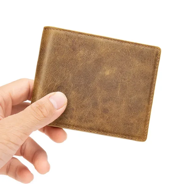 Hand holding a small vintage brown leather bifold wallet