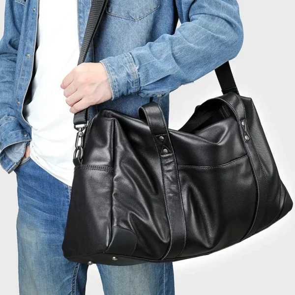 9 Man holding black leather duffle bag, casual denim outfit