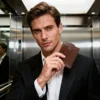 Business man holding a brown leather wallet in elevator