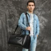 外模 (2) Man holding black leather duffle bag, casual denim style