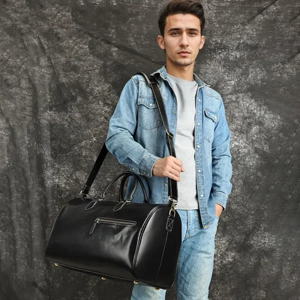 外模 (2) Man holding black leather duffle bag, casual denim style