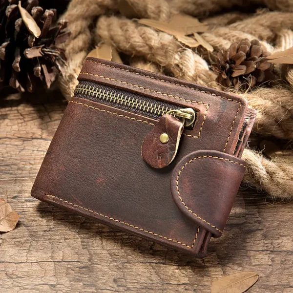 Brown leather zip wallet with snap closure, rustic background