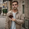 Young man holding a brown leather wallet, casual street style