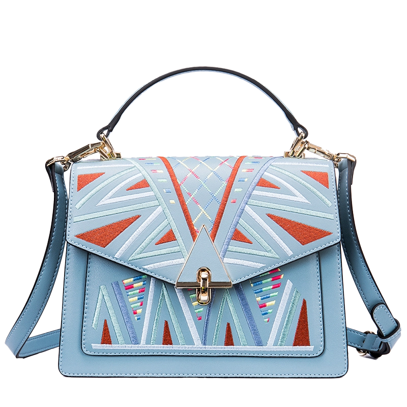Patterned blue leather crossbody bag, plain background