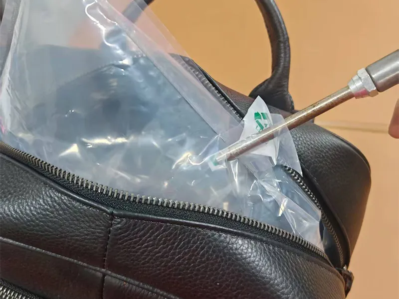 Quality inspector checks finished genuine leather bag