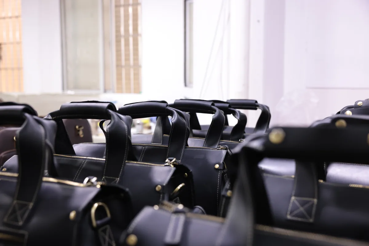 Finished black leather briefcases arranged together in the workshop