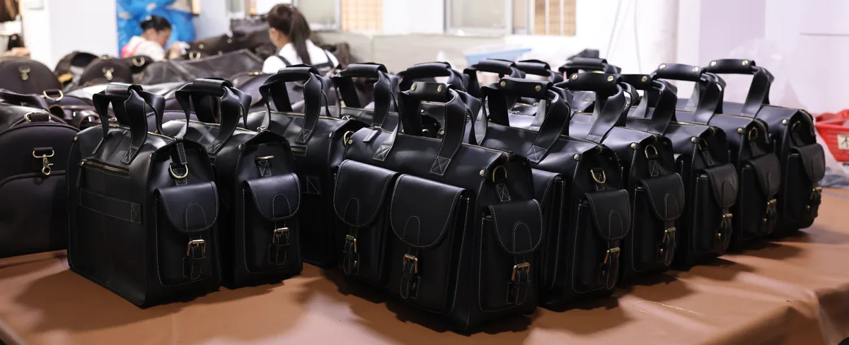 Rows of finished black leather bags arranged for batch checking