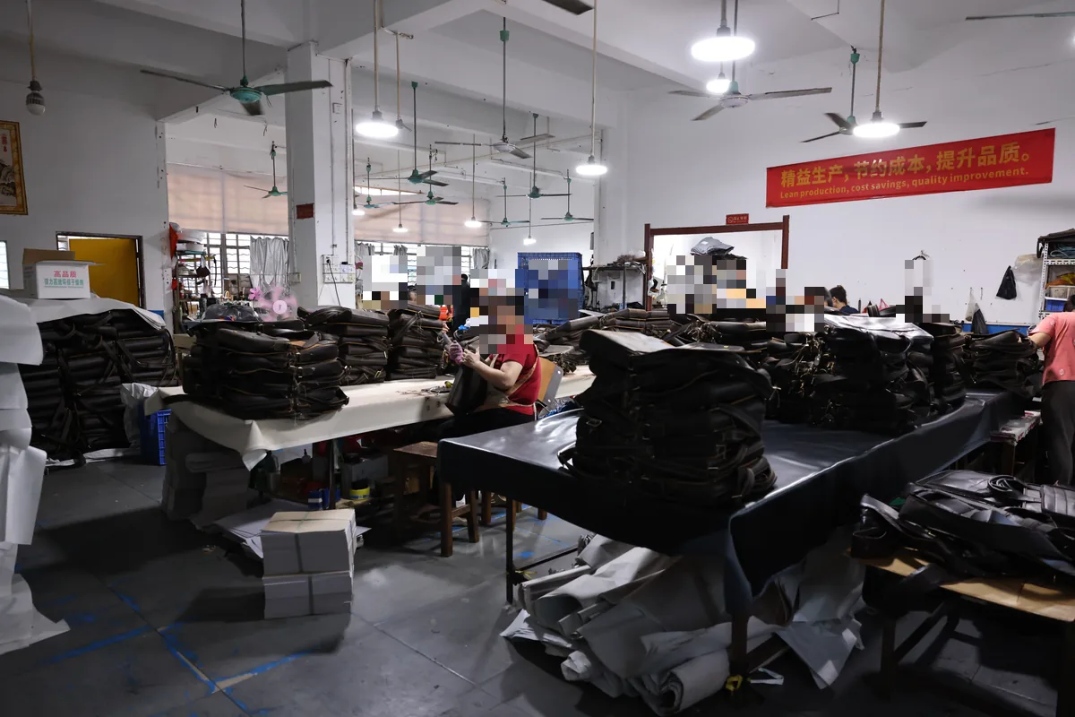 Leather bag factory Guangzhou production floor with completed bags and workstations