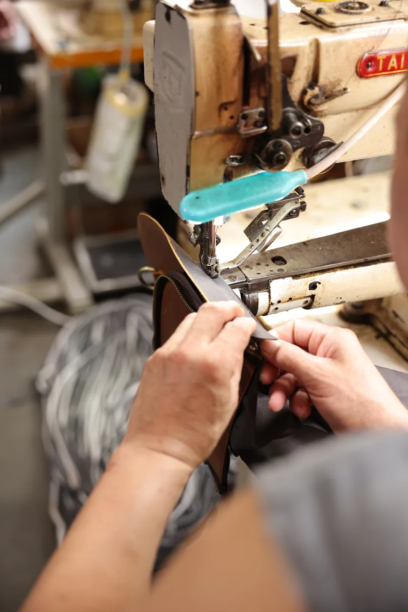 Close-up of a leather edge being guided through a factory machine
