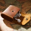 open brown Crazy Horse leather earphone pouch holding wired earphones