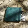 green Crazy Horse leather spring closure pouch holding earphones