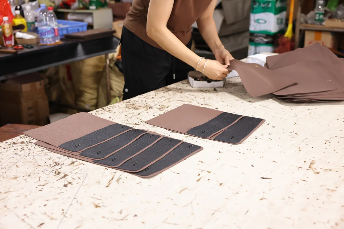 Cut brown leather bag panels arranged for production inspection