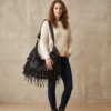 woman carrying a black genuine leather hobo shoulder bag with fringe