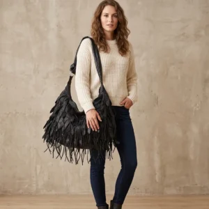 woman carrying a black genuine leather hobo shoulder bag with fringe